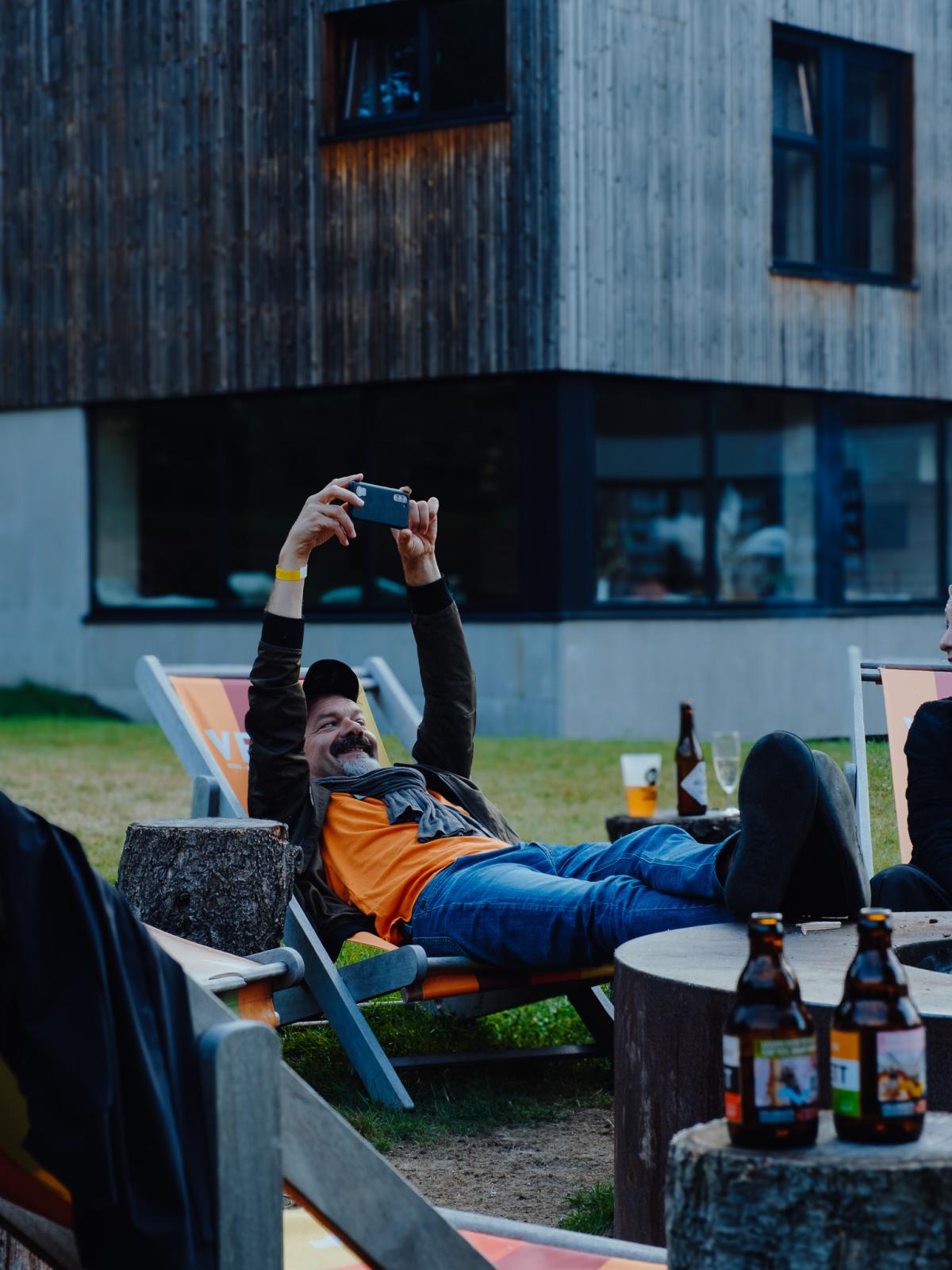 Une personne installée dans un transat profite du braséro et prend une photo lors d'une Daft Session